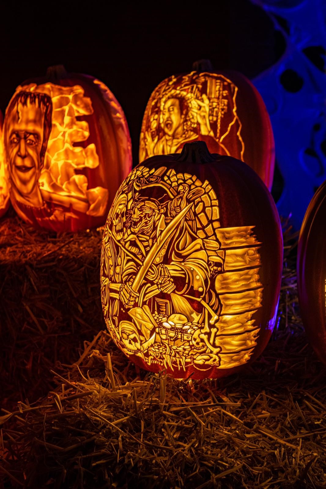 An elaborate display of intricately carved jack-o'-lanterns lit from within